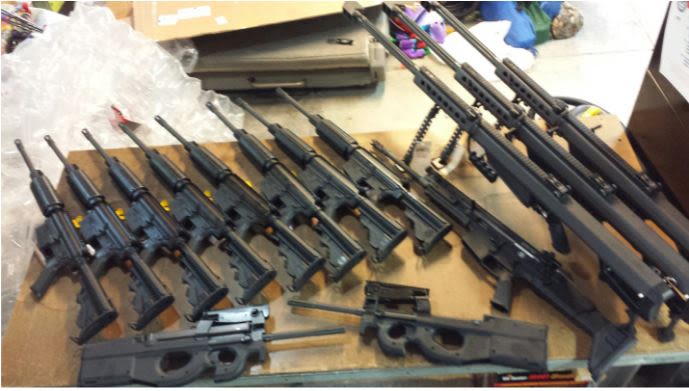 14 rifles of several sizes laid out on a table