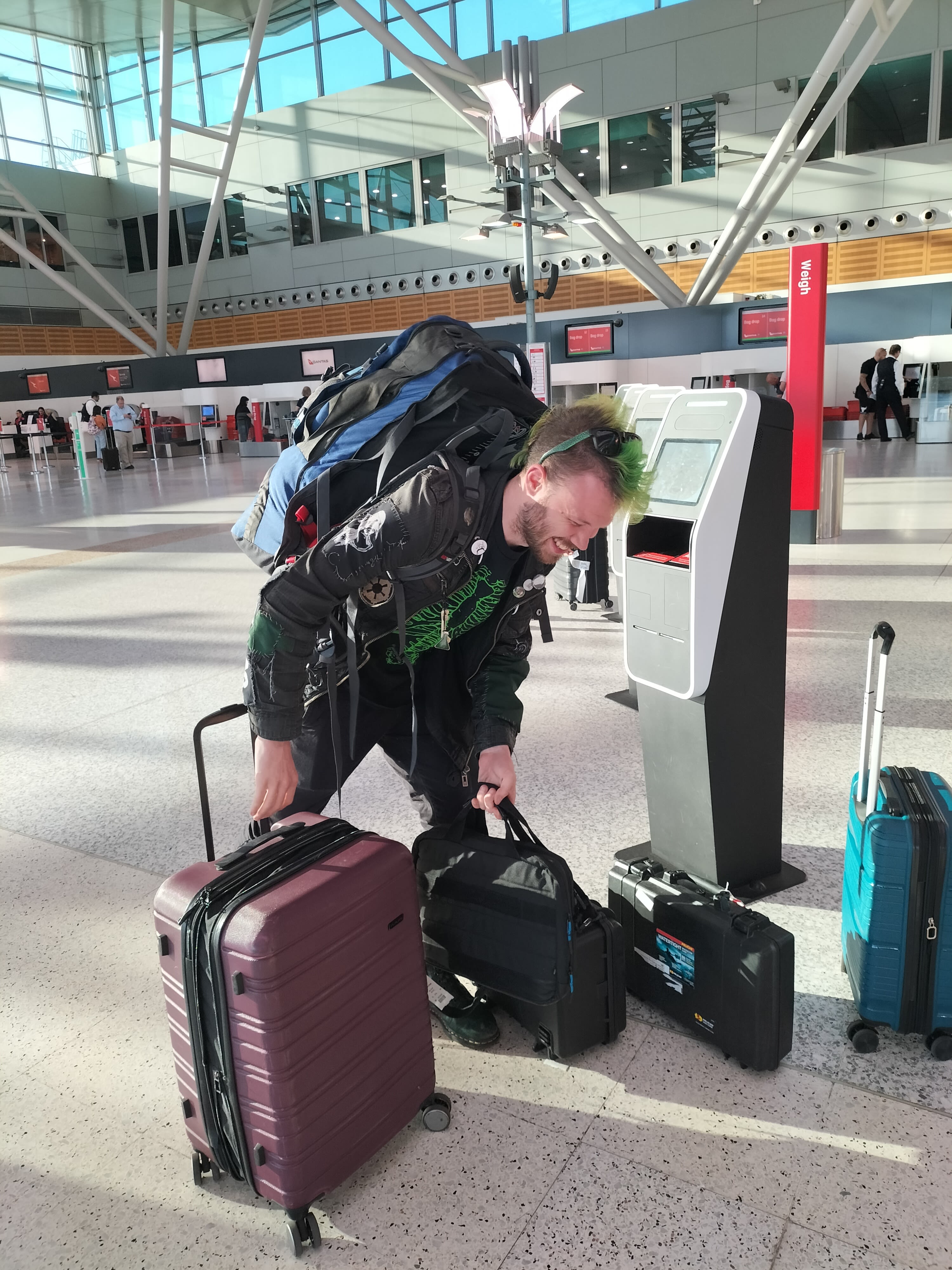A man holding bags at an airport