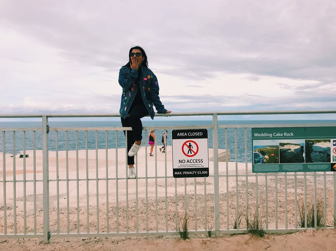 A tourist jumping the fence at Wedding Cake Rock