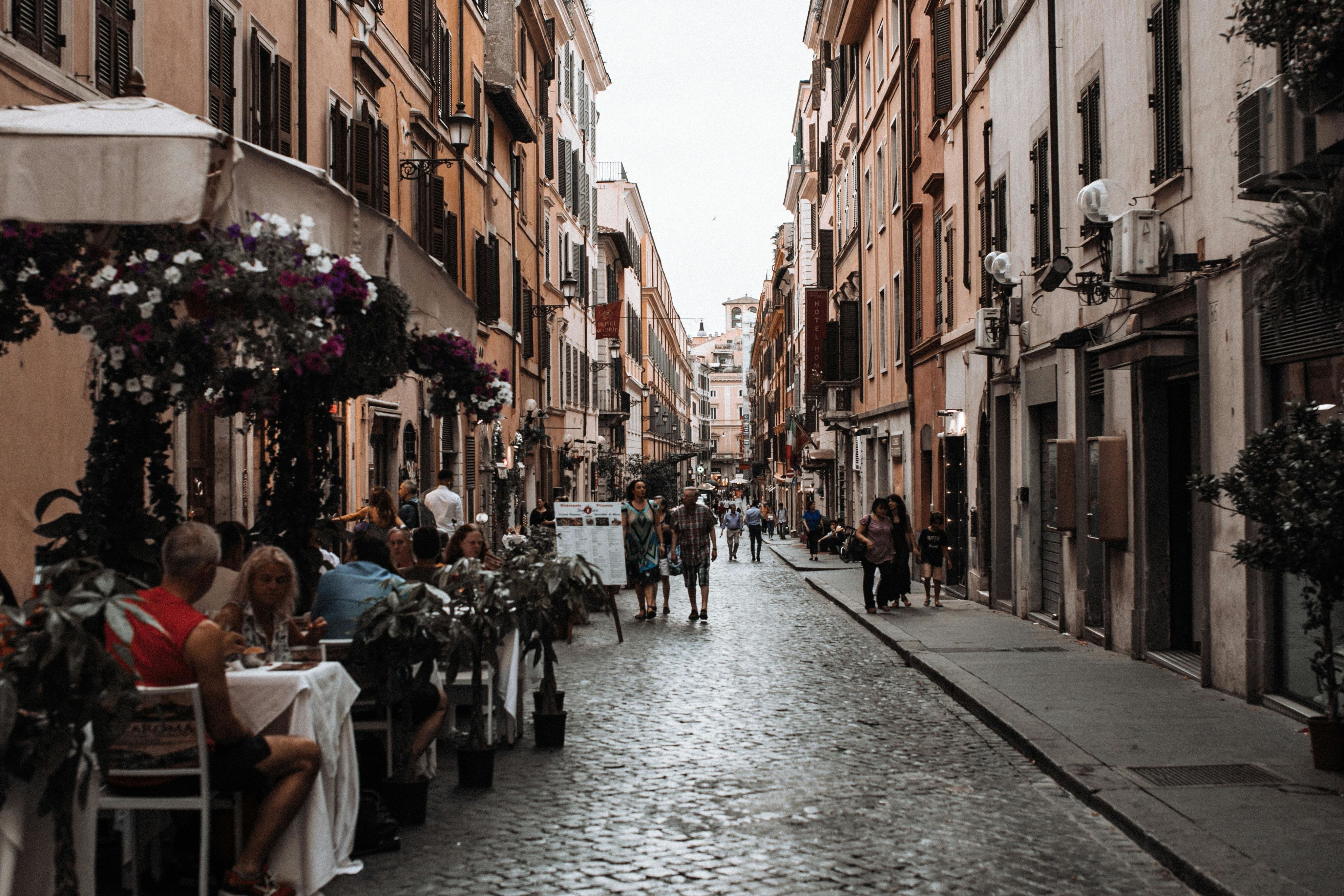 A Roman street with a restaurant and pedestrians